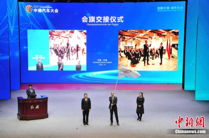 2021年10月19日，2021中德汽車大會在吉林長春舉行。中外汽車領域的專家學者、知名汽車廠商及汽車零部件企業(yè)代表和政府官員，圍繞“創(chuàng)新引領 綠色未來”主題展開探討。圖為中德汽車大會會旗交接儀式。高龍安 攝