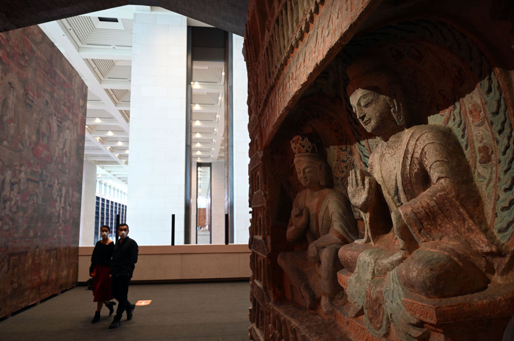 參觀者在中國國家博物館的“盛世修典——‘中國歷代繪畫大系’成果展”上觀看等比例高保真數字化3D打印復制的云岡石窟第6窟南壁“文殊問疾”屋形龕(2022年9月29日攝)。新華社記者 金良快 攝