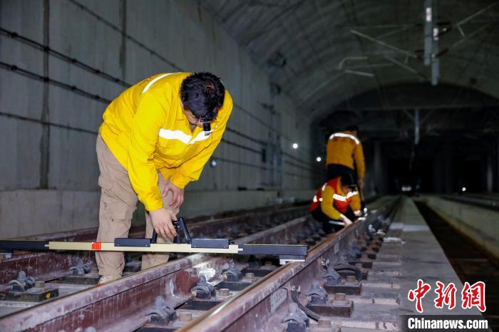 中國鐵路南寧局集團(tuán)有限公司南寧工務(wù)段職工使用道尺檢查吳圩機(jī)場高鐵站高鐵線路設(shè)備?！№f剛 攝